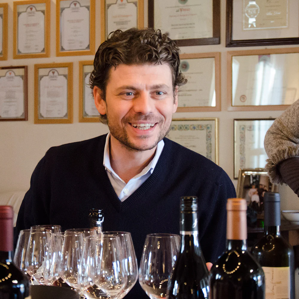 photo of San Simone natural winery owner Antonio Brisotto in front wine bottles and glasses