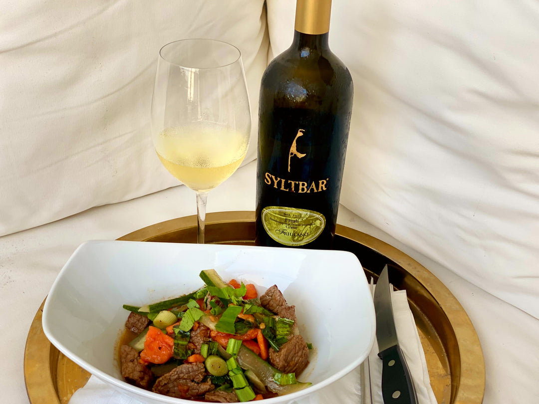 Papaya and Beef Salad on plate with wine