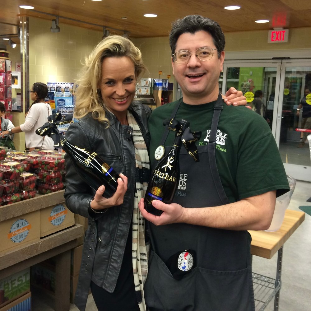 photo of SYLTBAR owner Regina and Whole Foods Market employee holding bottles of Mr SYLTBAR low-sugar prosecco